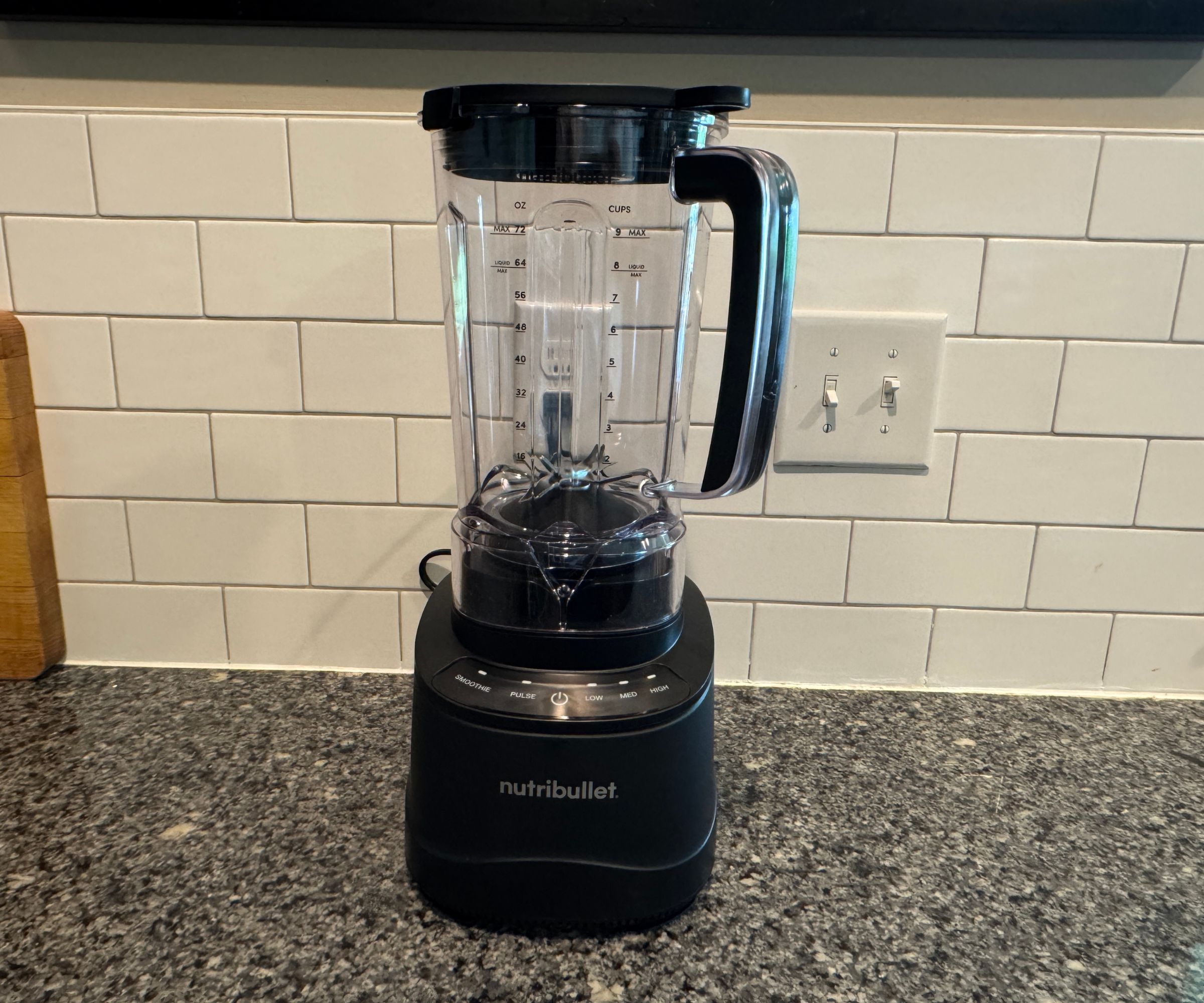 Ein Nutribullet PowerCore XL-Mixer auf einer Küchentheke aus Stein vor weißen U-Bahn-Fliesen.
