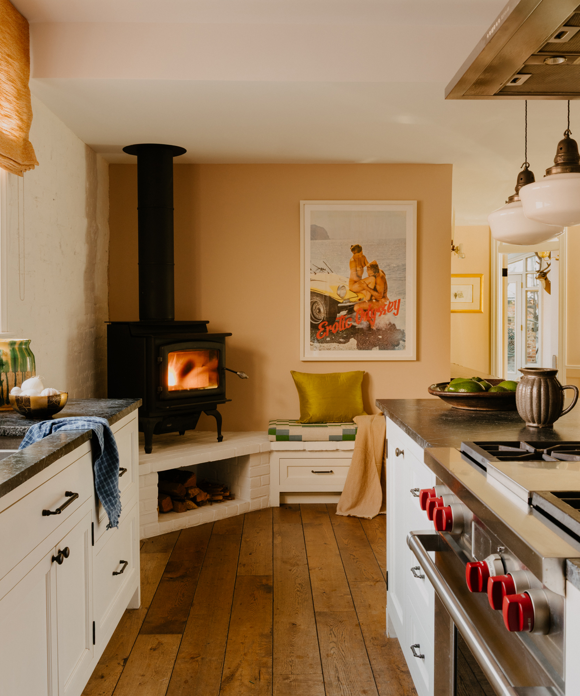 Küche mit Kamin in der Ecke und weißen Schränken