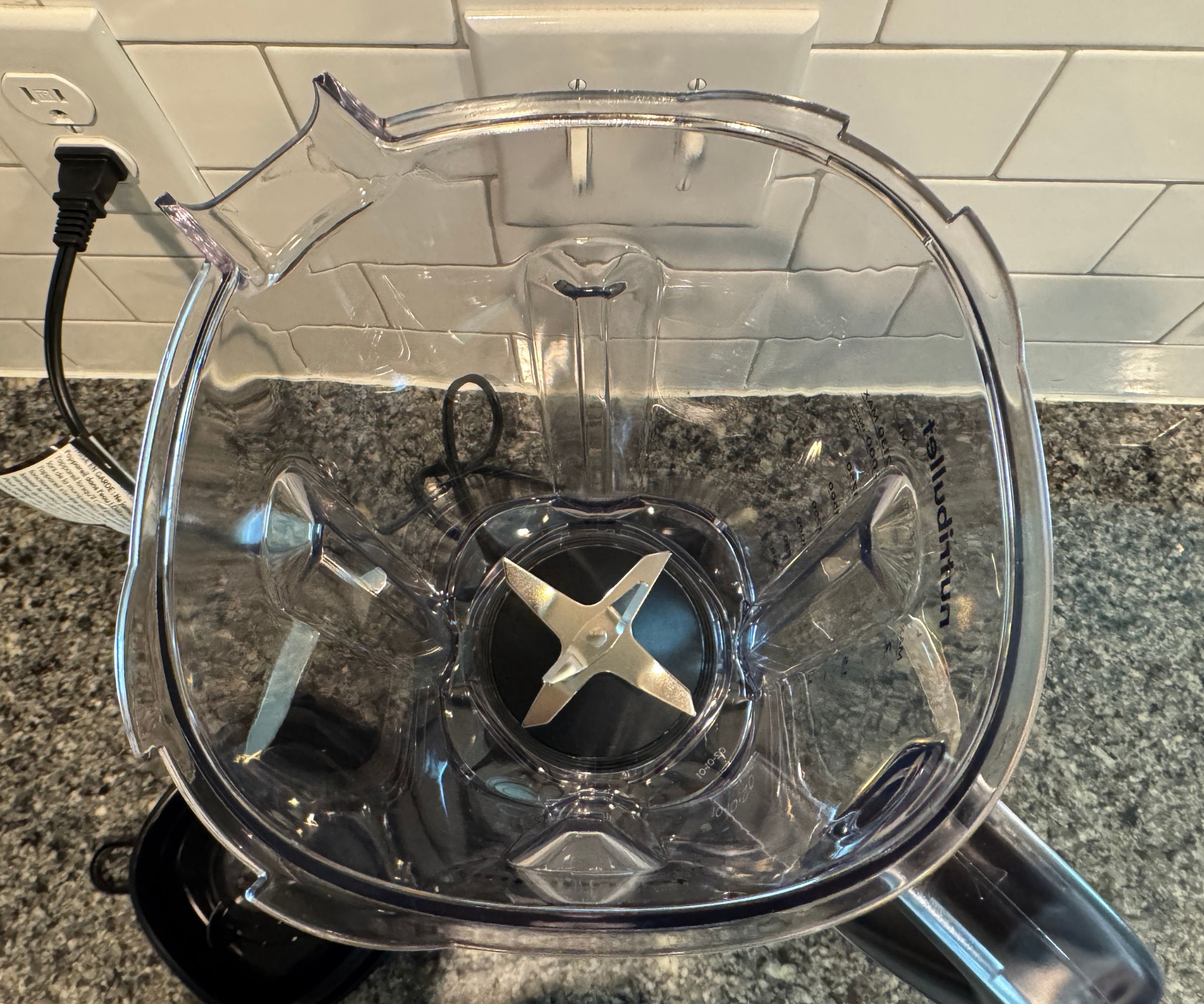 Die Innenseite des durchsichtigen Kunststoffkrugs eines Mixers mit Edelstahlklingen.