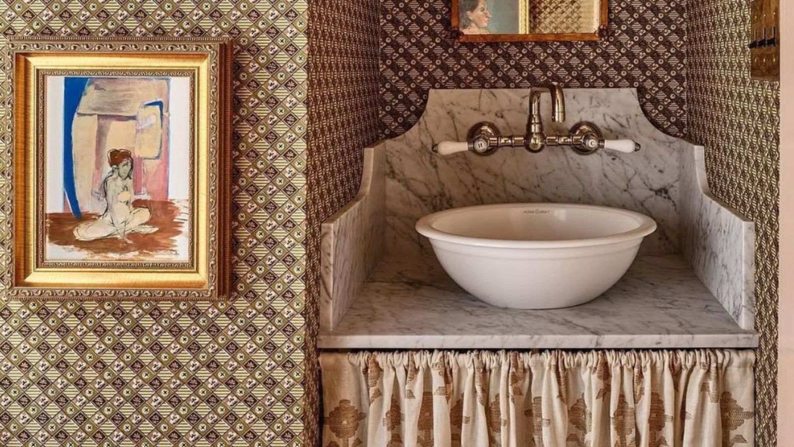 Ein gemustertes, tapeziertes Badezimmer mit einem Waschtisch mit Schürze