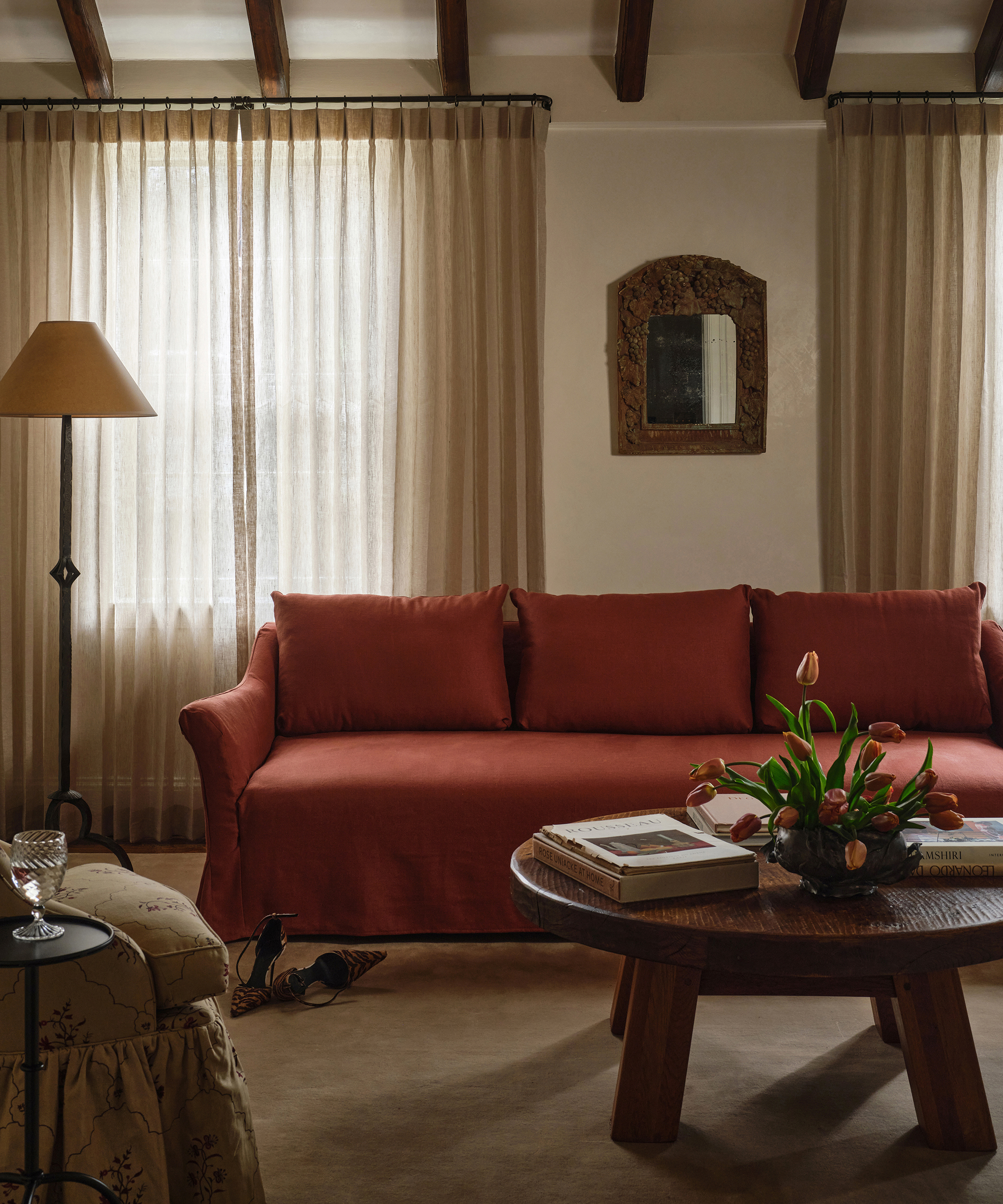Wohnzimmer mit rotem Sofa und Tulpen auf dem Couchtisch