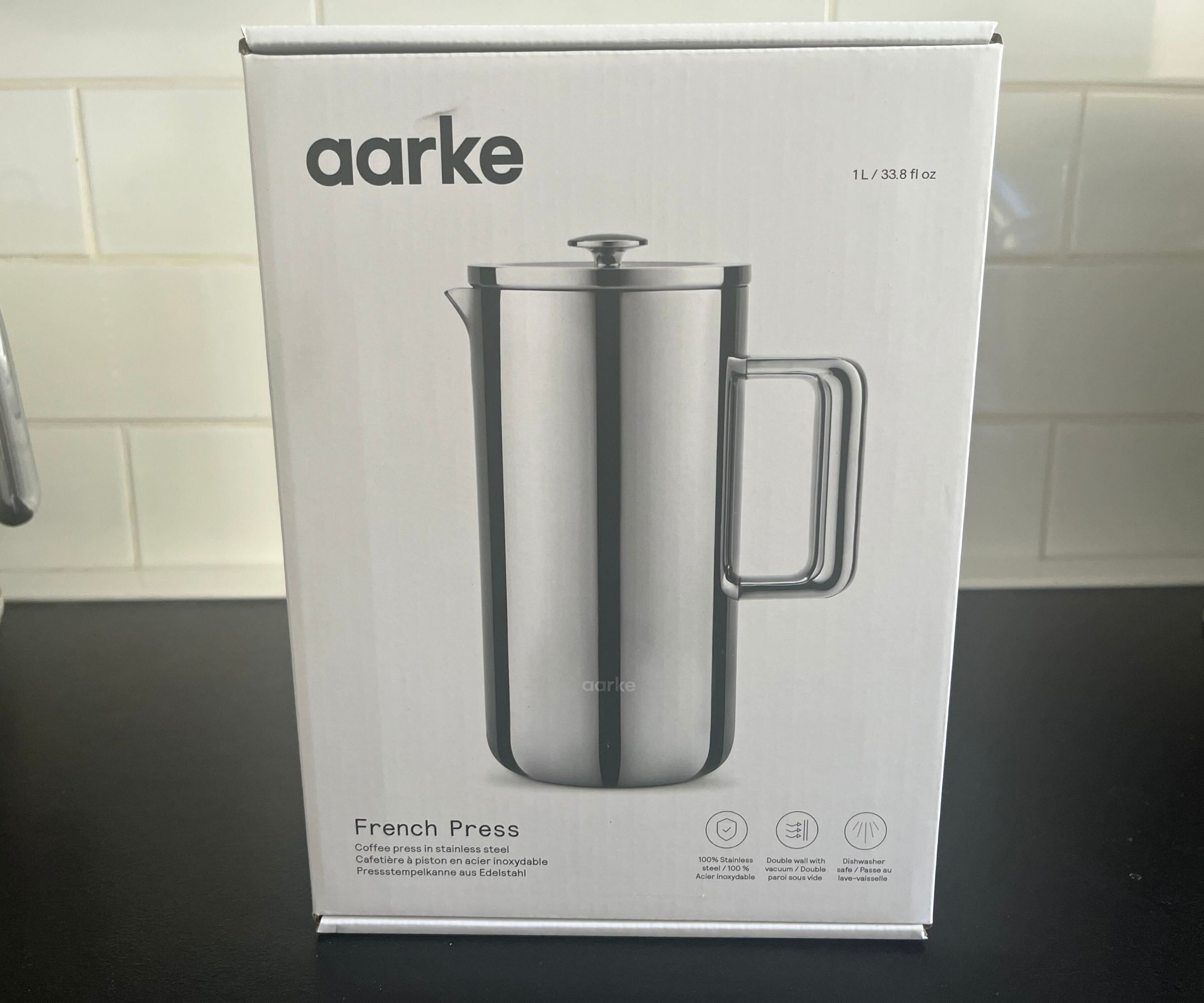 Die weiße Box für die Aarke-Kaffeepresse mit einem Bild der Edelstahlpresse auf der Vorderseite.