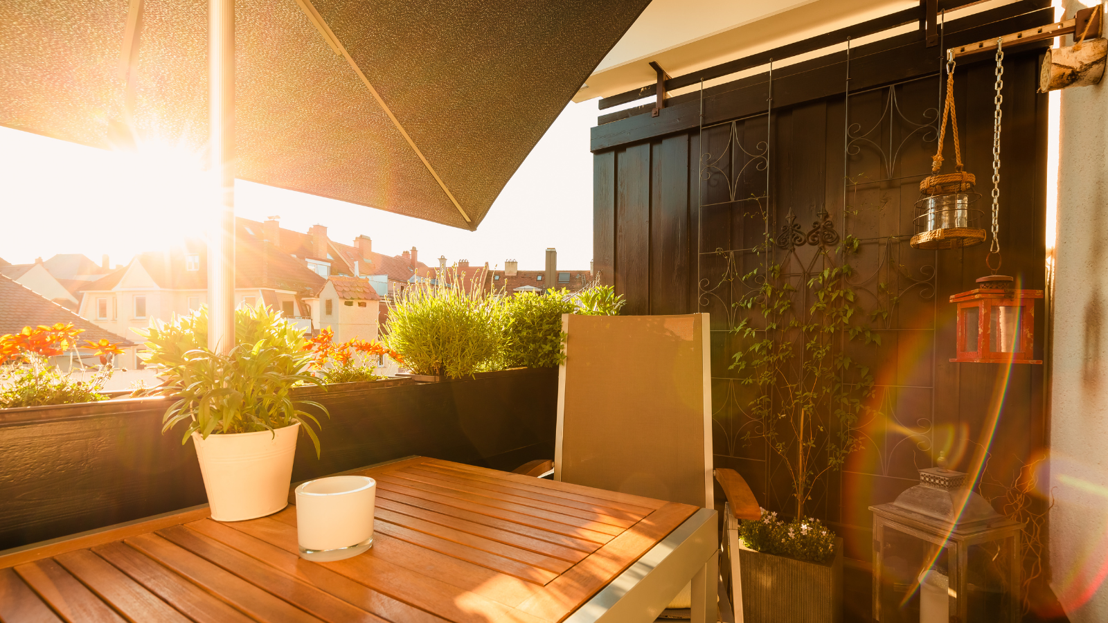 Kleiner Balkon mit Pflanzen und Sonnenschirm im Stadtgebiet