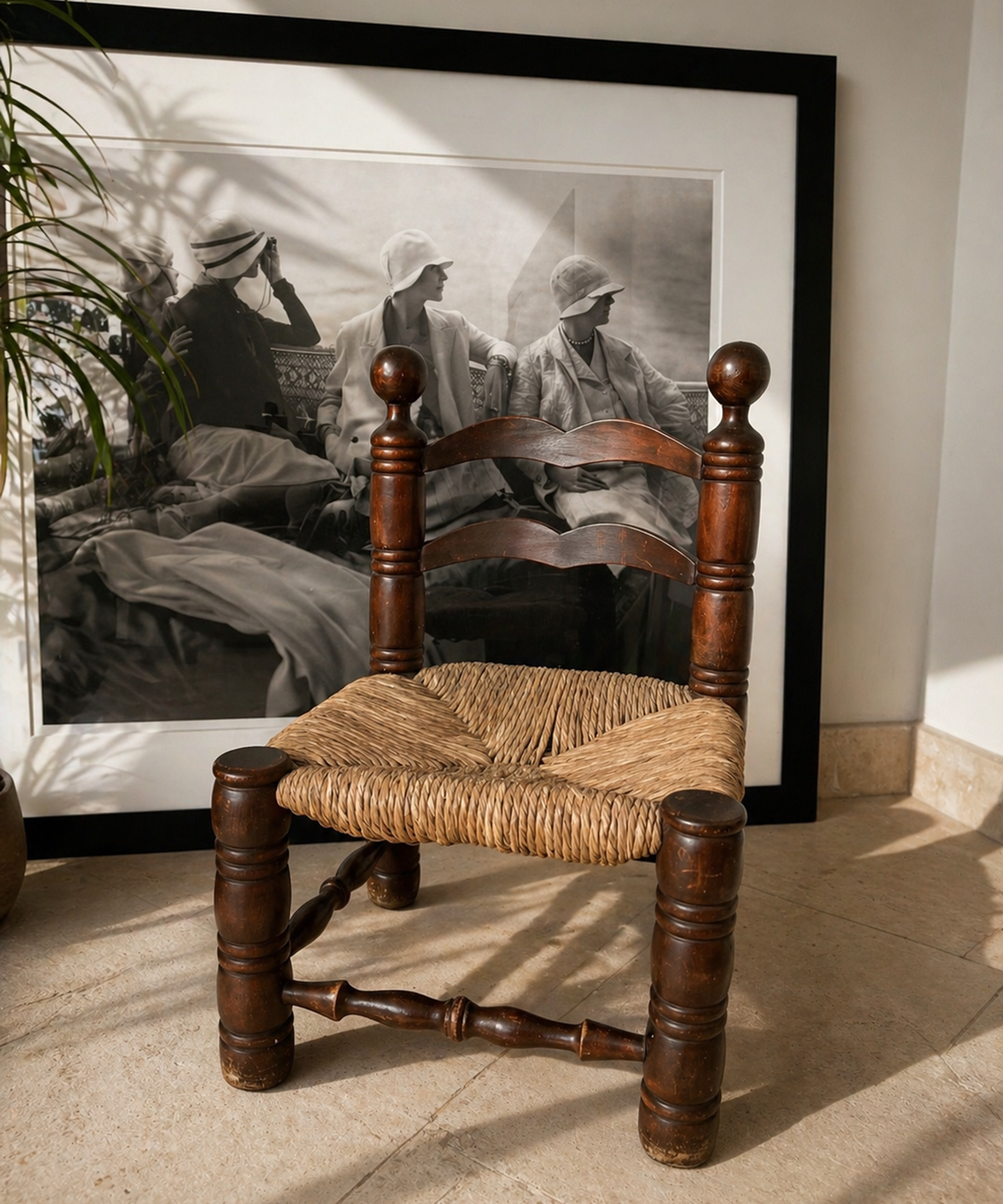 Vintage-Holzstuhl mit Rattangestell vor einem schwarz-weißen Kunstdruck