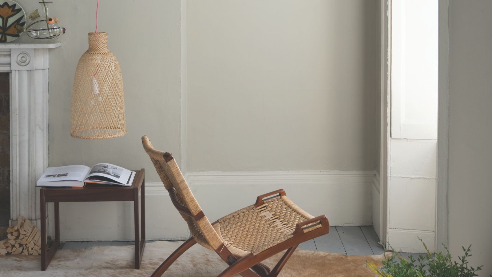Wohnzimmer mit Drop Cloth-Bemalung und Rattan-Loungesessel in der Mitte