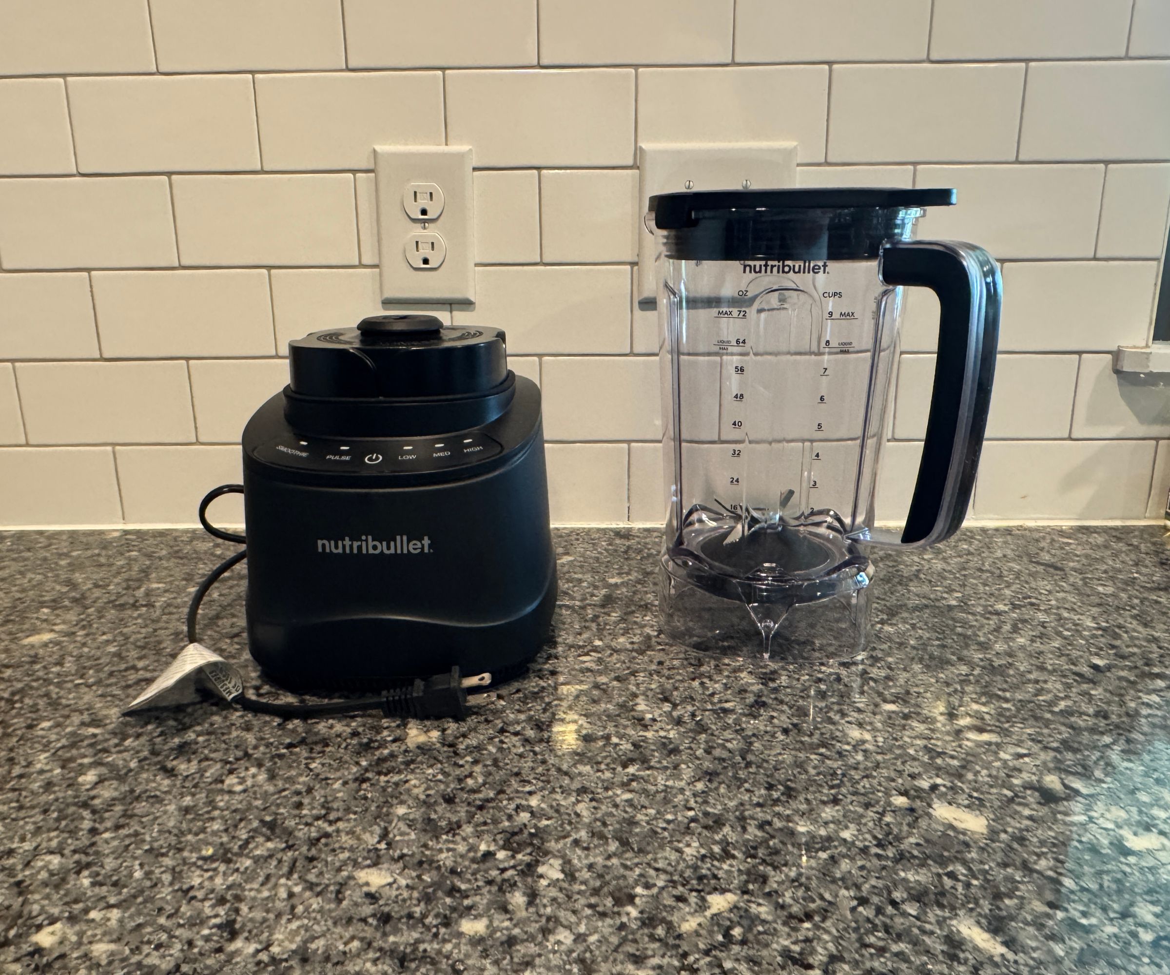 Der Nutribullet PowerCore XL-Mixer besteht aus zwei Teilen – dem schwarzen Motorsockel und dem durchsichtigen Krug – auf einer Küchentheke aus Stein vor einer weißen Fliesenrückwand
