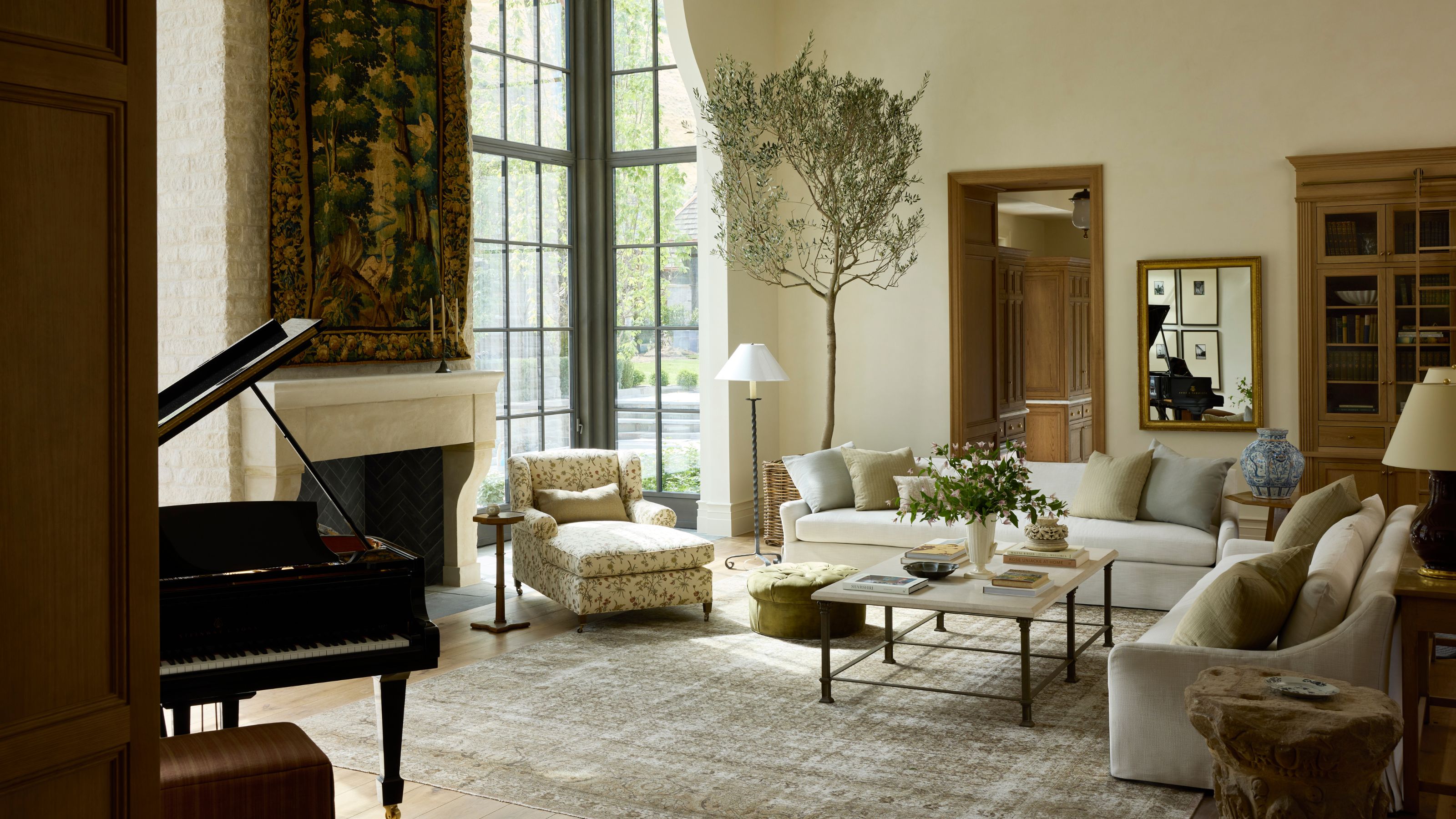 Ein riesiger Great Room in Utah mit großen Glasfenstern, die vom Boden bis zur Wand reichen, einem Steinkamin mit einem Wandteppich darüber, einem Klavier und einer gemütlichen Sitzecke