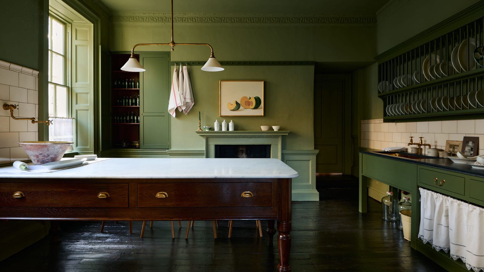 Grüne deVOL Heirloom-Küche mit freistehendem Milchtisch mit Marmorarbeitsplatte, offenem Tellerregal, bemalten Schränken, dunklem Holzboden und historischen architektonischen Details.