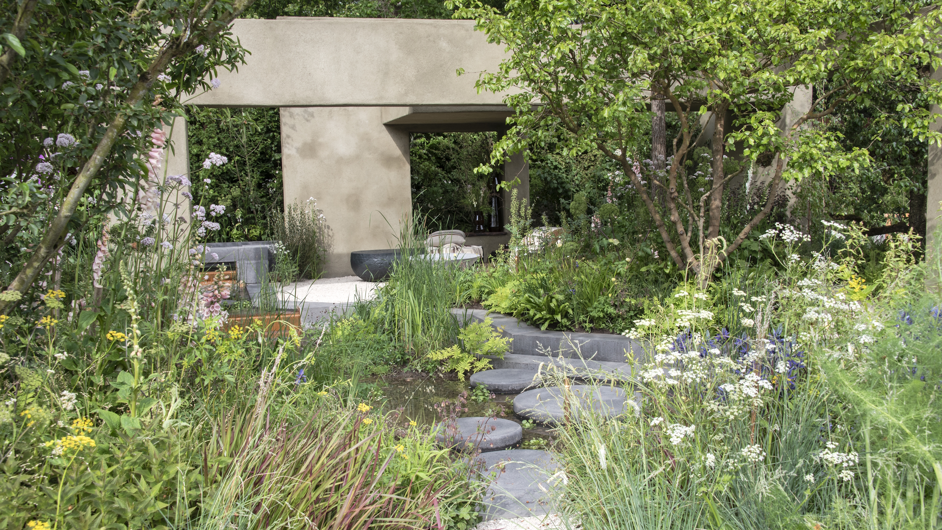 Blühende Staudenrabatten und ein Sitzbereich aus Stein auf der Chelsea Flower Show 2026