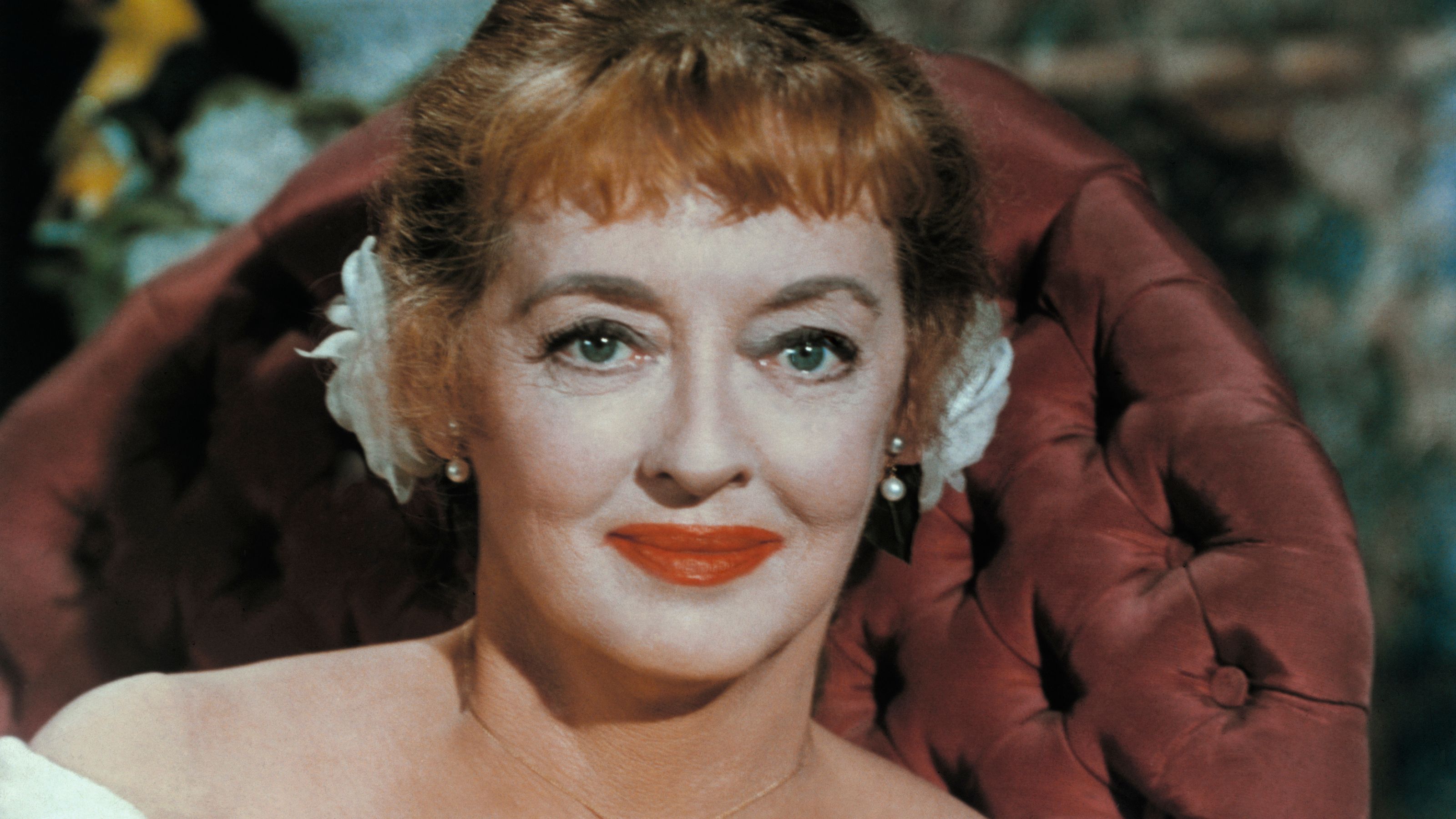 Bette Davis auf einem roten Stuhl