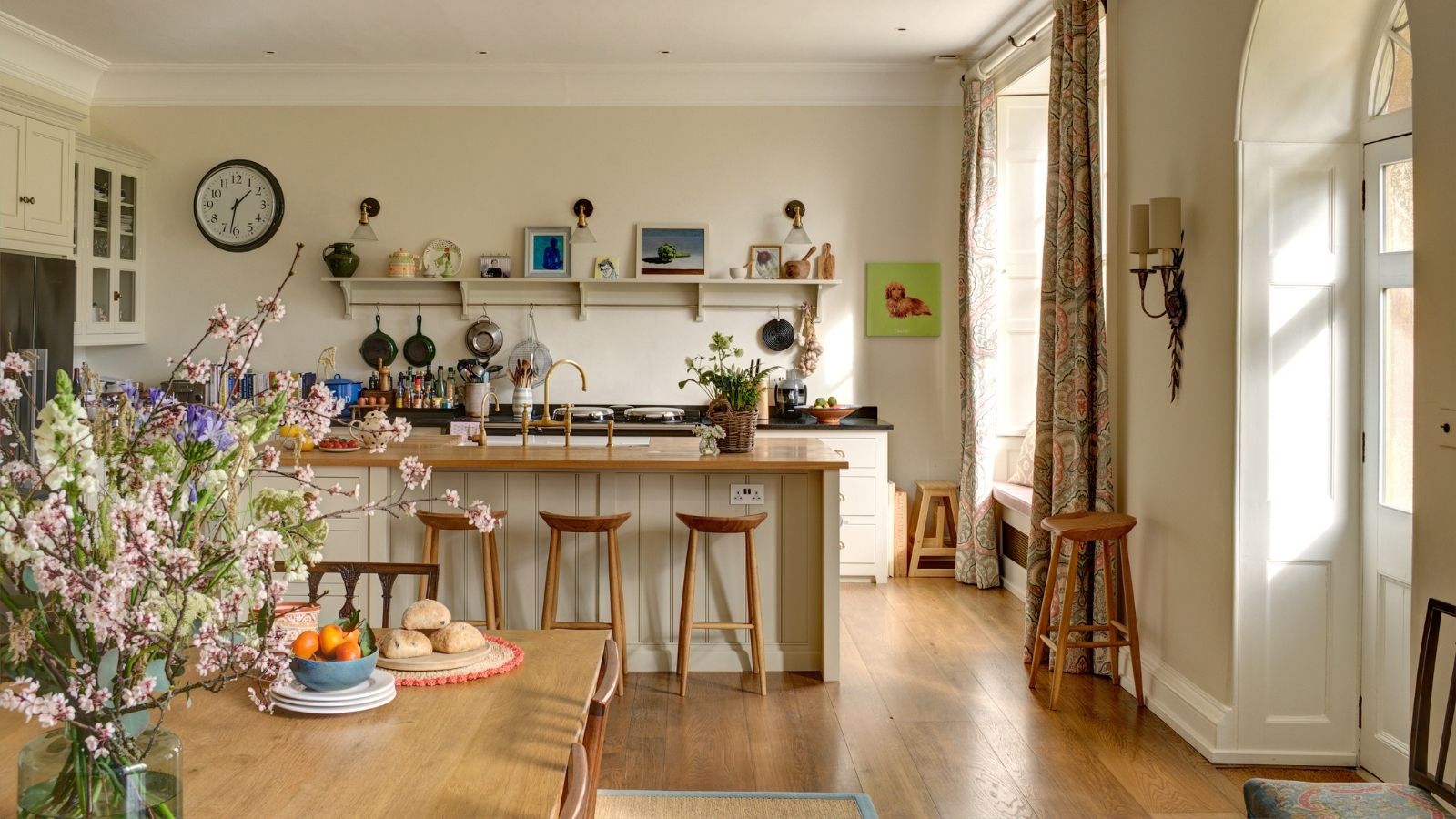 Eine offene Wohnküche im Landhausstil mit Holzböden, Theken und offenen Regalen