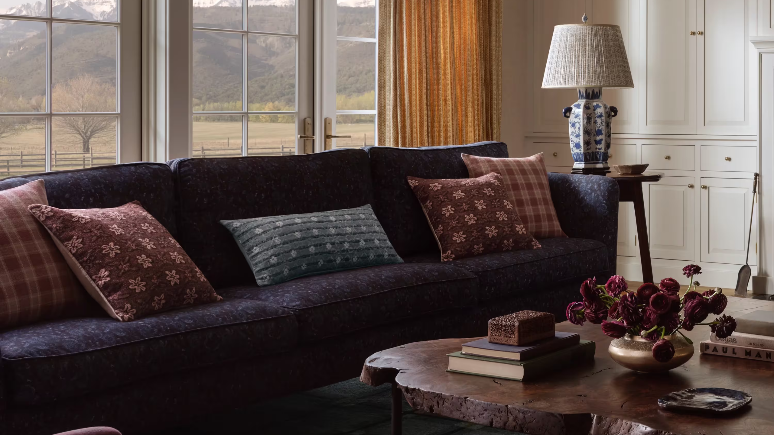 a cozy living room with a blue couch and several decorative fall throw pillows