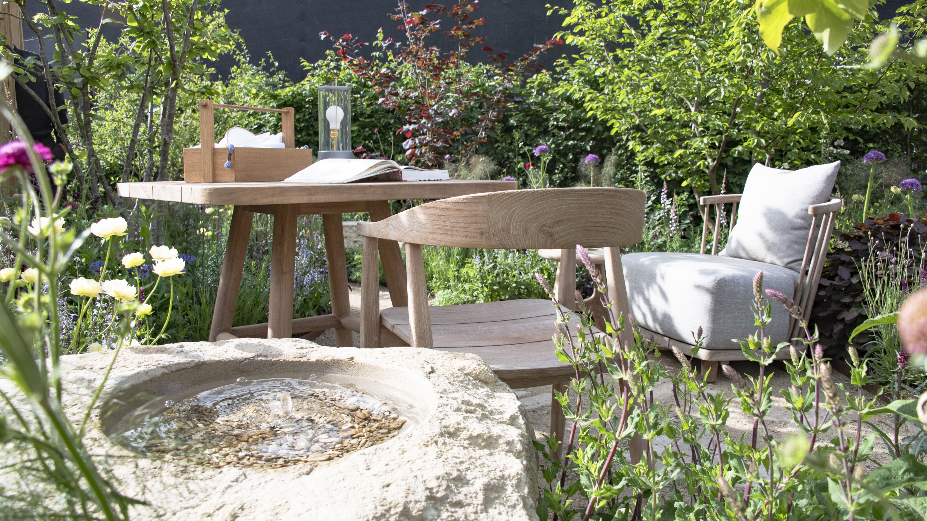 Eine Essgruppe aus Holz in der Mitte eines Schaugartens auf der RHS Chelsea Flower Show 2026