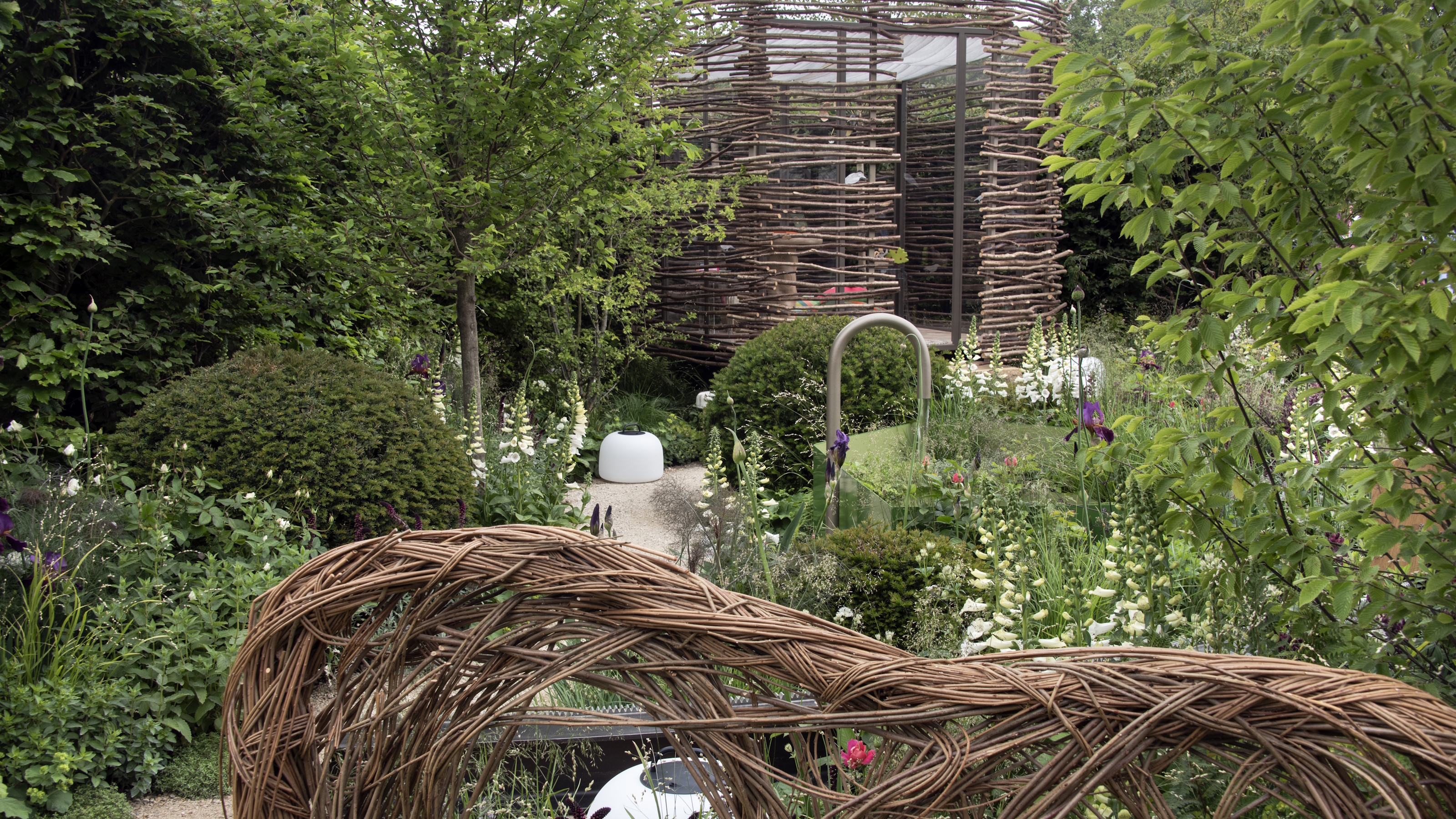 Ein Sommergarten mit Korbgeflecht, Bäumen und weißen Blumen auf der RHS Chelsea Flower Show 2026