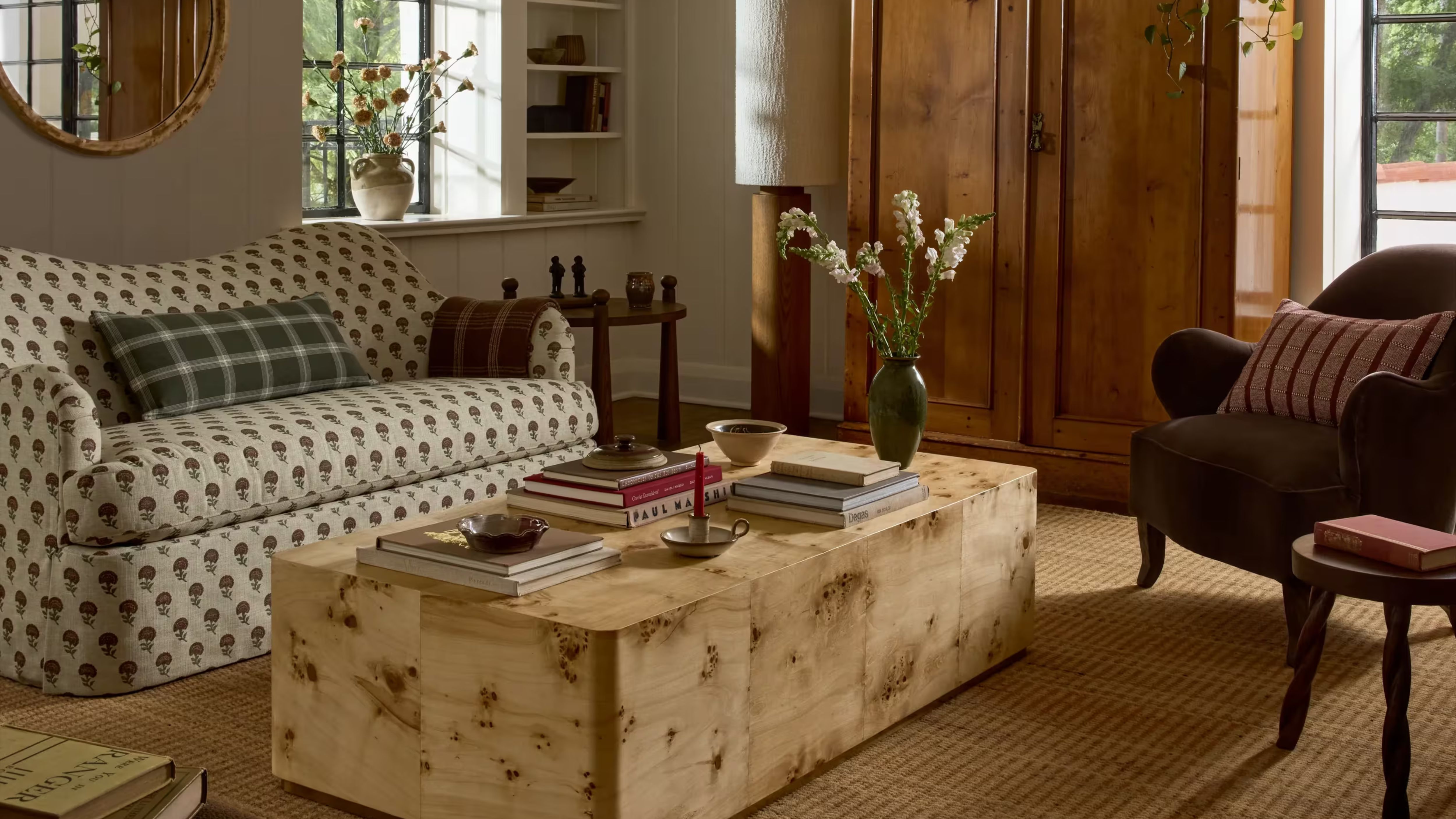 Kleines gemütliches Wohnzimmer mit Couchtisch aus Wurzelholz und gemustertem Sofa