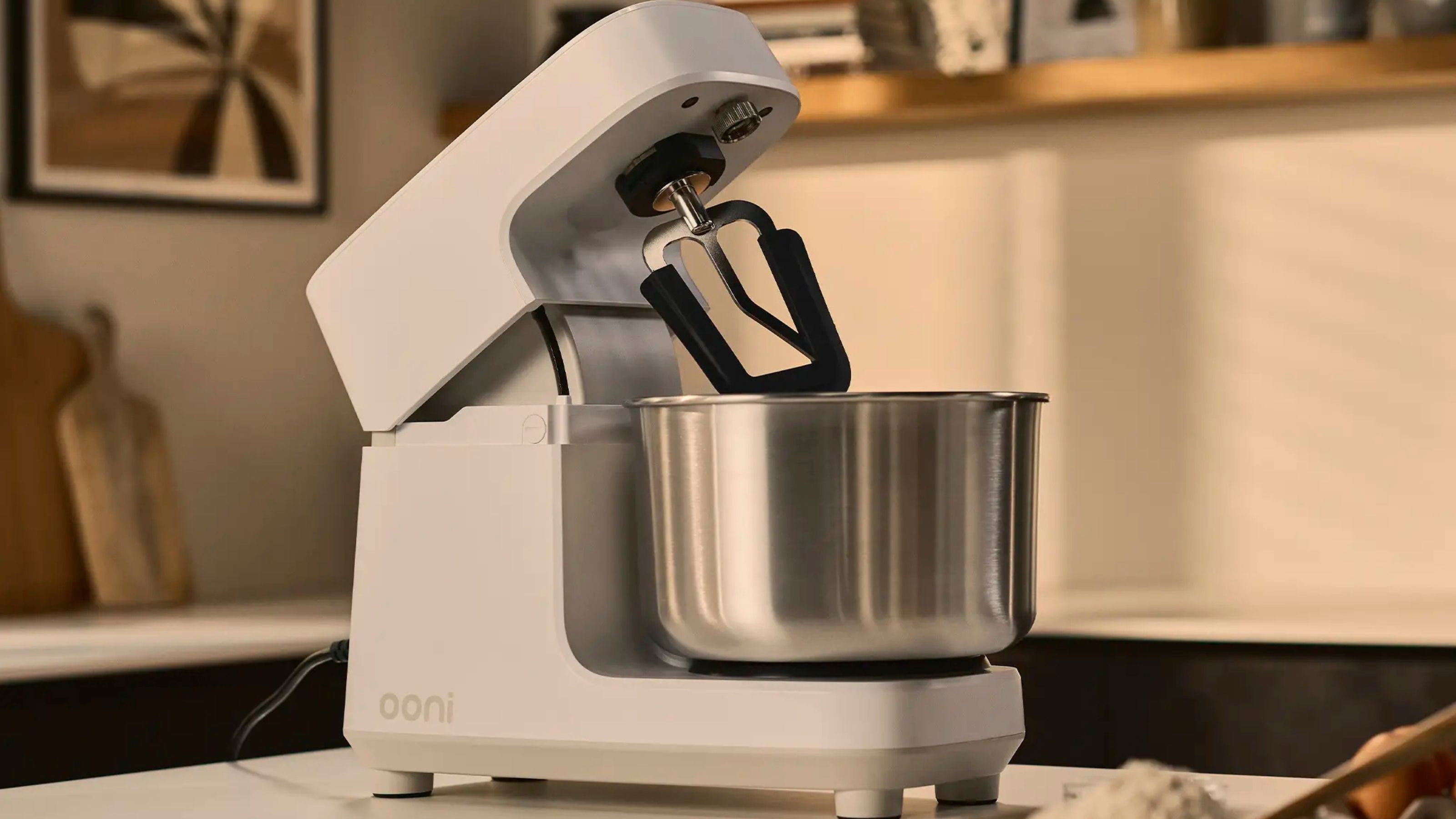 Ein weißer Ooni Halo Core Spiralmixer auf einer Küchentheke, mit nach hinten geneigtem Kopf. 