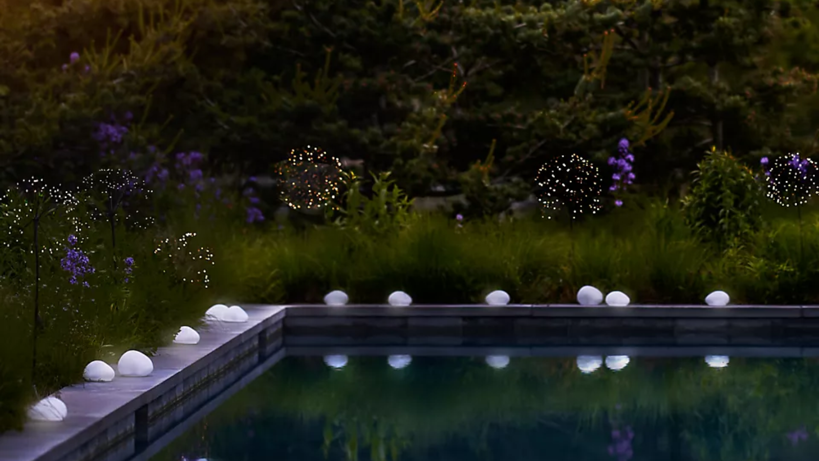 ein Pool mit Solarkiesellichtern drumherum