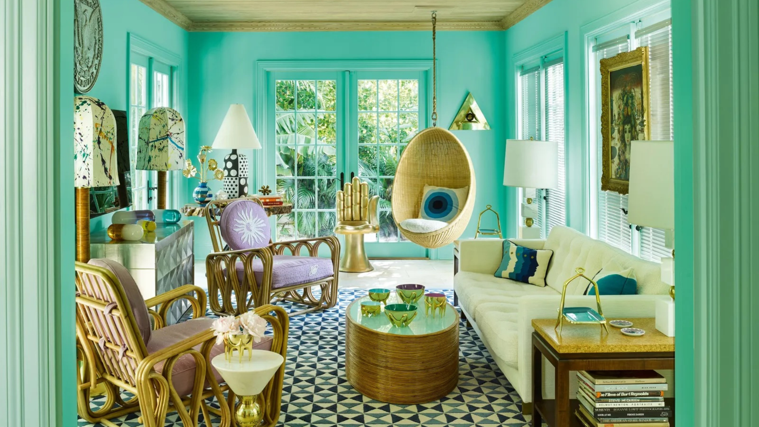 In Tiffany-Blau getauchtes Wohnzimmer mit geometrisch gefliesten Böden und einer eklektischen Mischung aus Rattanmöbeln und Messingakzenten. 