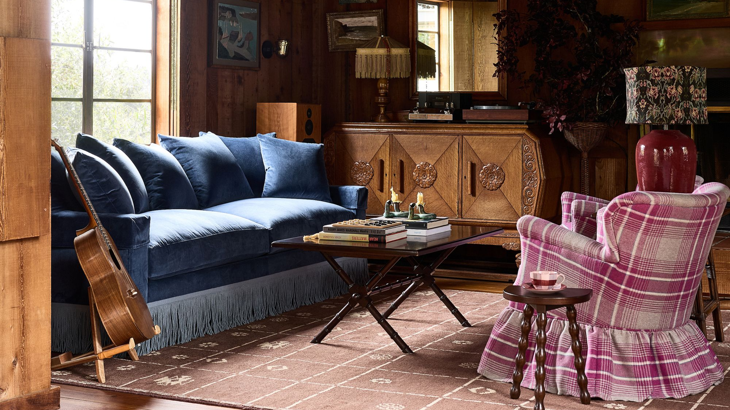ein gemütliches Wohnzimmer mit einem Akzentstuhl mit kariertem Rock und einem Sofa mit blauen Fransen